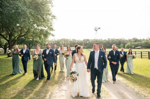 bride and groom walking outdoors with bridal party
